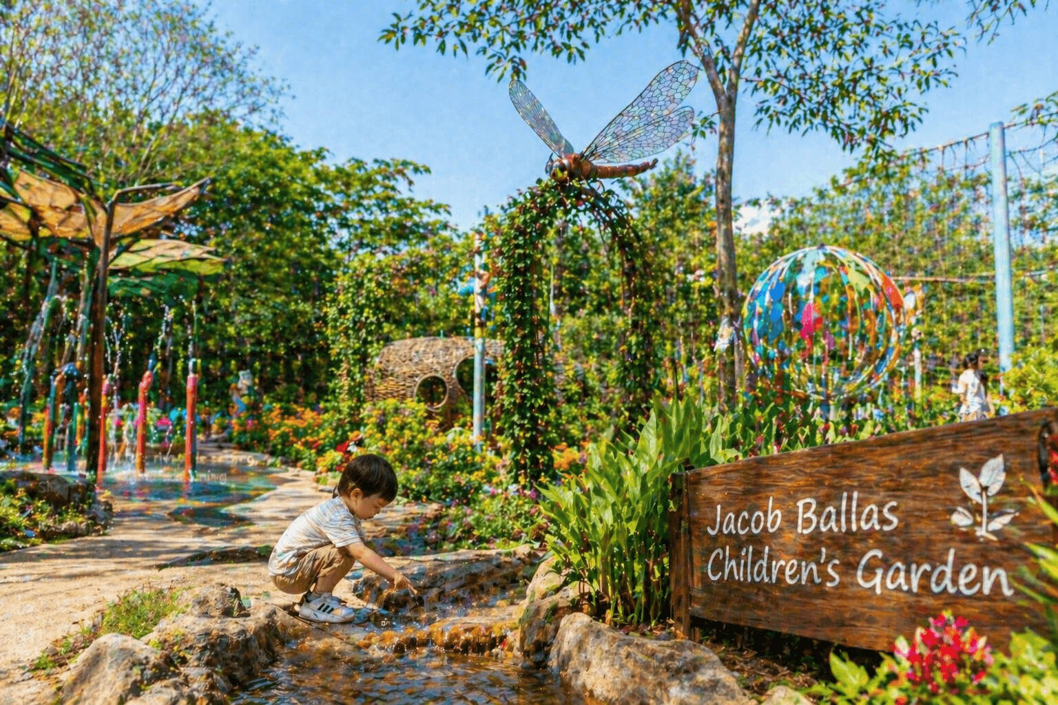 Toddler playing at Jacob Ballas Children’s Garden in Singapore with water features and colorful play area.