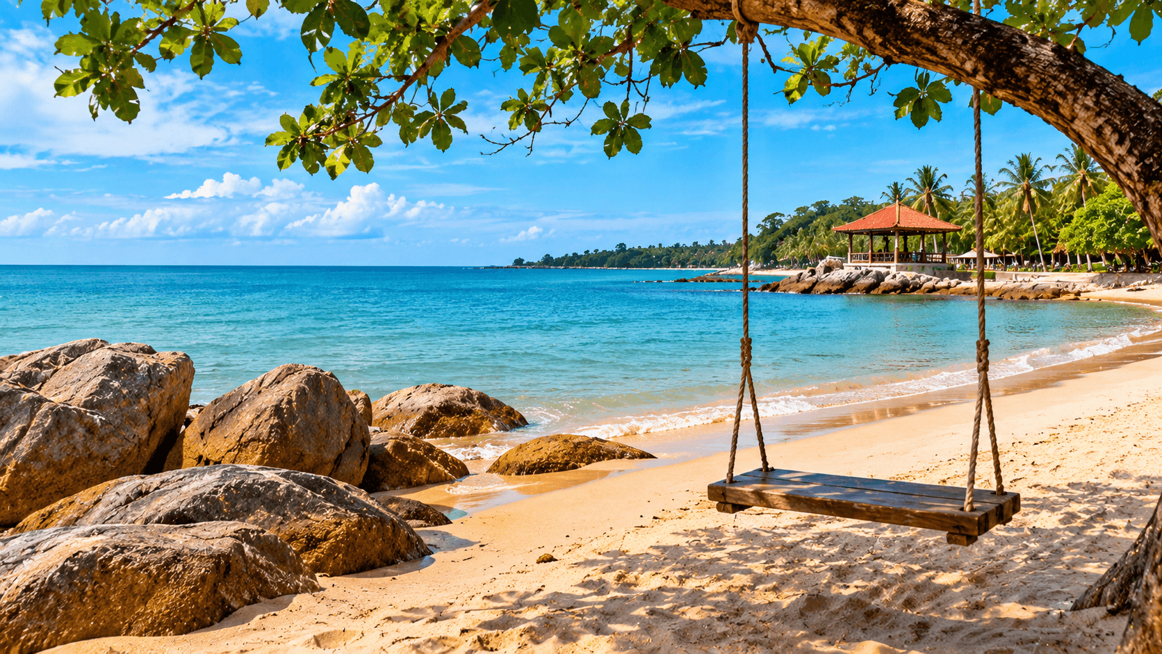 Tropical beach near Kota Bharu featuring clear turquoise water, a sandy shoreline, palm trees, and a shaded coastal gazebo.